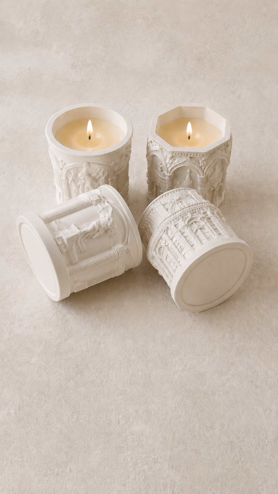 Set of 4 white gypsum candle holders with relief detail soy candles burning marble background close up | MOSVAM
